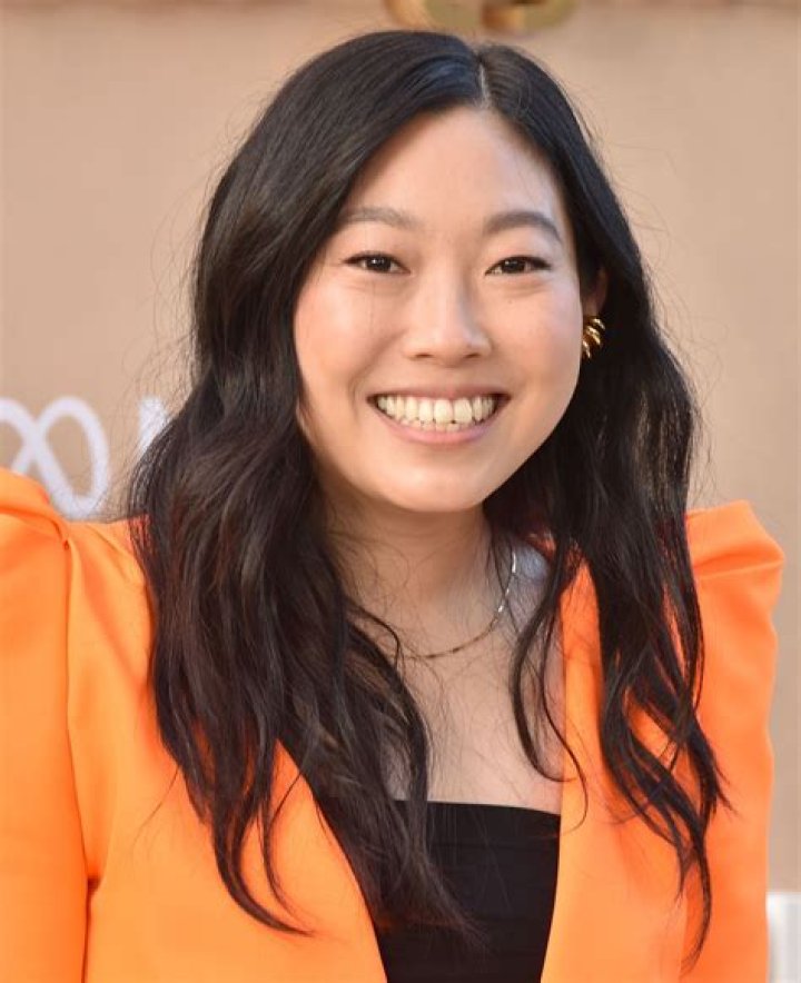 Awkwafina shows off a sparkly orange dress