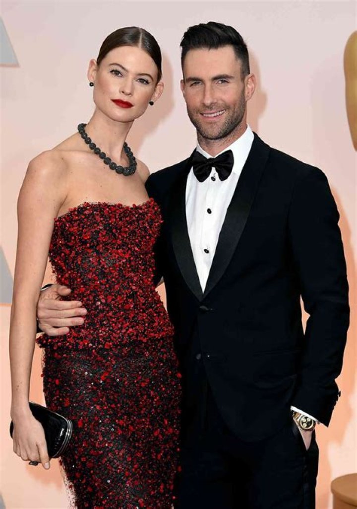 Behati Prinsloo and Adam Levine are joined by their two oldest kids on a hammock during the 'Middle Ground' music video