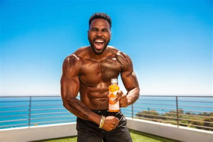 Jason Derulo’s GF Jena Frumes Sweetly Cradles Son Jason King, 4 Weeks, In Orange Mini Dress