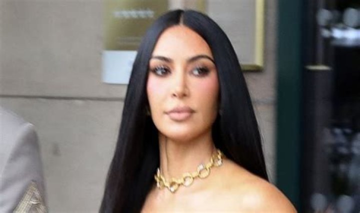 Kim Kardashian puts on a silver trench coat as she arrives for a Skims shoot in LA.