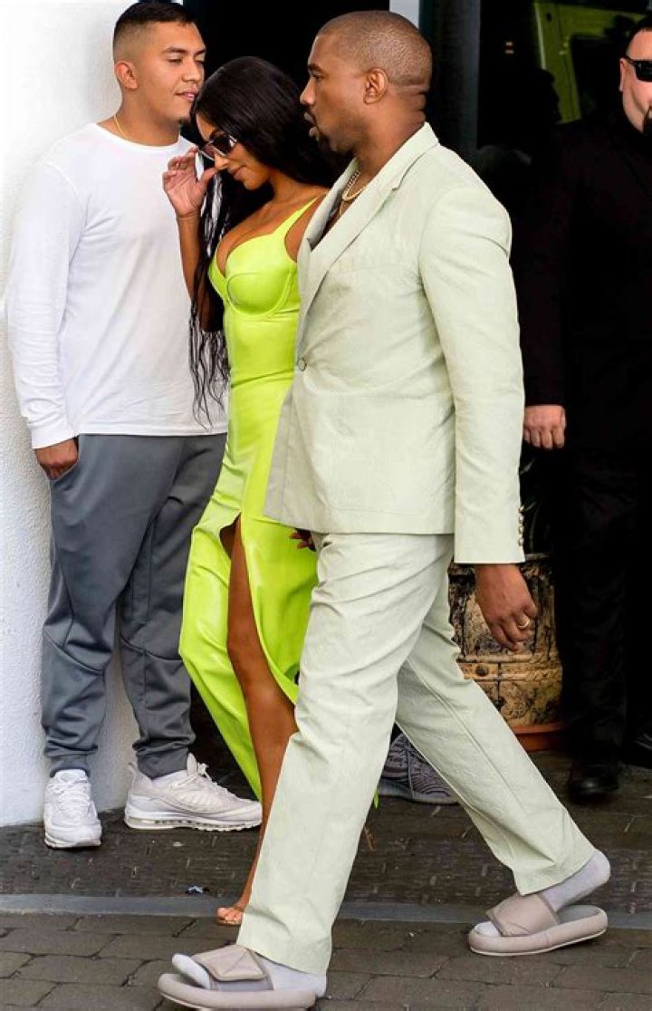 Kim Kardashian shined extra bright in neon and she and Kanye West arrive at Miami's Versace Mansion for rapper 2 Chainz's wedding on Saturday, Aug. 18. The fashion diva wore a fluorescent yellow gown for the extravagant ceremony, while her hubby bared his chest in a light colored suit. Rapper 2 Chainz was tying the knot with fiancee Kesha Ward at Gianni Versace's famed Casa Casuarina on Ocean Drive. The celebrity arrivals caused a major buzz for tourists who stopped to snap photos. sPictured: Kim Kardashian,Kanye WestRef: SPL5016965 180818 NON-EXCLUSIVEPicture by: AM/Brian Prahl/Splash News / SplashNews.comSplash News and PicturesLos Angeles: 310-821-2666New York: 212-619-2666London: 0207 644 7656Milan: +39 02 4399 8577Sydney: +61 02 9240 Rights