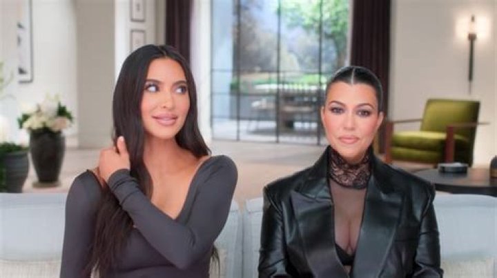 Kourtney Kardashian and sister Kim Kardashian wearing black dresses