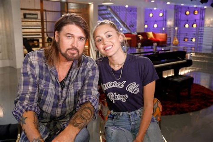 Miley Cyrus and Billy Ray Cyrus performing on stage 