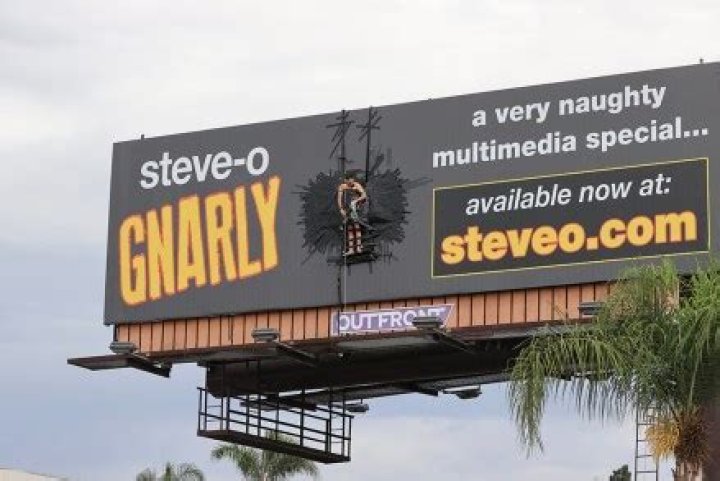 Steve-O Duct Tapes Himself To A Billboard & Assures Fans There’s ‘Zero Chance’ That He’ll Fall